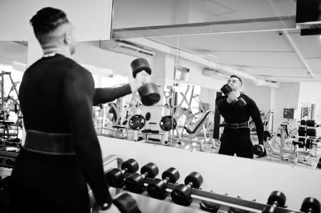 Muscular arab man training with dumbbells in modern gym.の写真素材