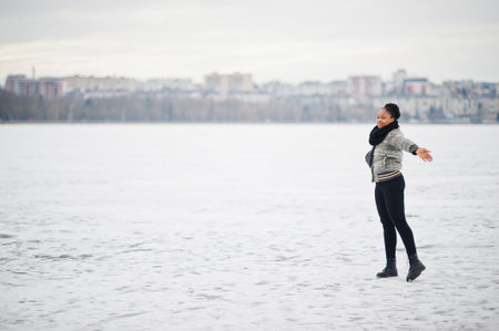 African woman wear in black scarf pose in frozen ice lake, winter day at Europe.の写真素材