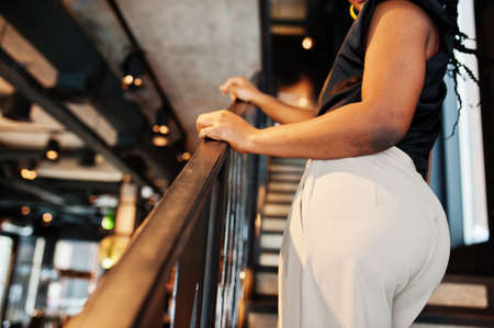 Cropped image of buttocks african woman in black blouse at cafe.の写真素材