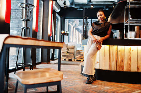 Young african woman in black blouse at cafe.