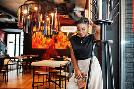 Young african woman in black blouse at cafe.