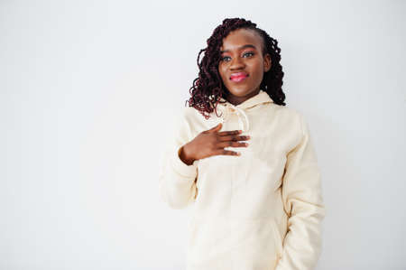 African woman in hoodie stand against white wall.の写真素材