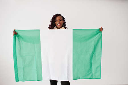 Nigerian woman hold Nigeria flag isolated on white wall.の写真素材