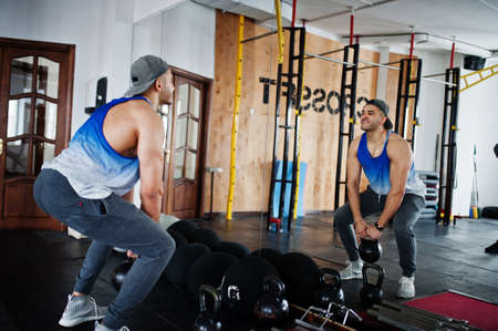Fit and muscular arabian man doing workouts in gym.