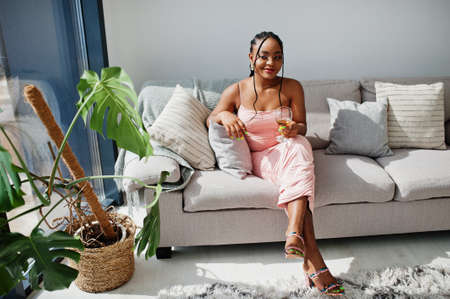 Fashionable photo of young beautiful romantic african american woman with glass of wine, wearing...
