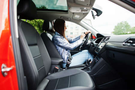 Gorgeous woman sitting inside car with open door.