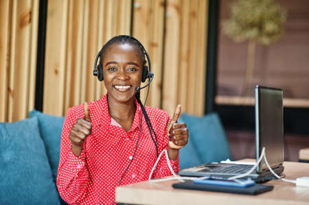 African american woman works in a call center operator and customer service agent wearing microphone...