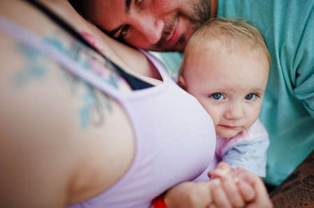 Summer vacations. Parents and people outdoor activity with children. Happy family holidays. Father, pregnant mother, baby daughter on sea sand beach.の写真素材