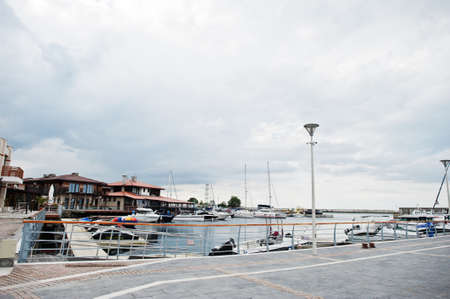 Marine parking of modern motor boats with jet skies. Luxury yachts docked in sea port.