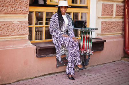 Beautiful african american woman natural makeup wear fashion clothes casual black and white dress code office style total blouse and pants suit and hat.の写真素材