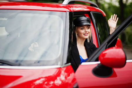 Portrait of beautiful blonde sexy fashion woman model in cap and in all black, blue corset, with...