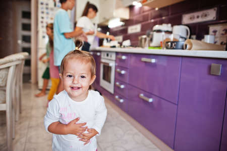 Small cutie baby girl in kitchen. Cooking with mother.の写真素材