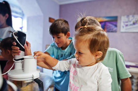Mother with kids cooking at kitchen, happy children's moments. Work with a blender.の写真素材