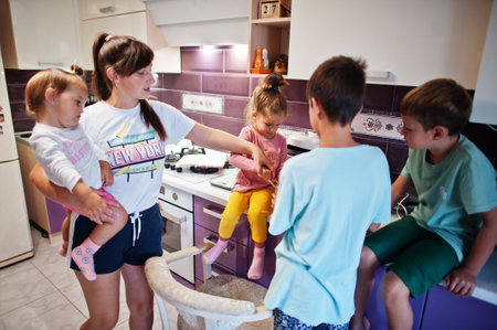 Mother with kids cooking at kitchen, happy children's moments.の写真素材