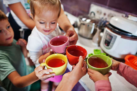 Mother with kids drink compote at kitchen, happy children's moments.の写真素材