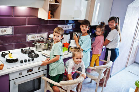 Mother with kids cooking at kitchen, happy children's moments.の写真素材