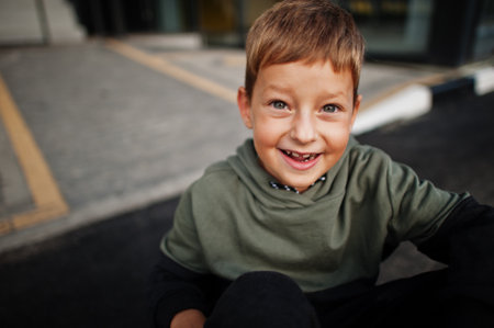 Close up portrait of smiled sitting boy in sport suit.の写真素材