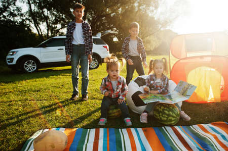 Four kids spending time together. Outdoor picnic blanket.の写真素材