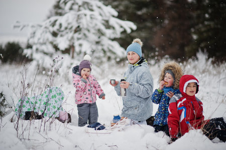 Mother with kids at winter day drink hot tea.の写真素材
