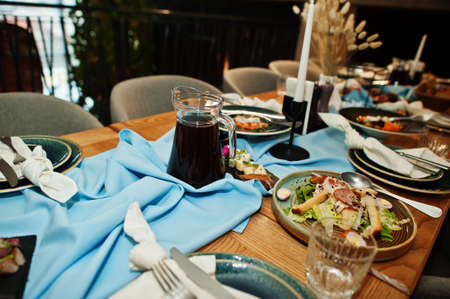 Beautifully laid tables with food, glasses and appliances in restaurant.の写真素材