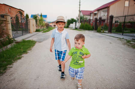Two brothers walking holding hands, brother love.の写真素材