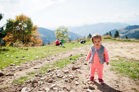Cute baby girll waliking in mountains. Little discoverer.の写真素材