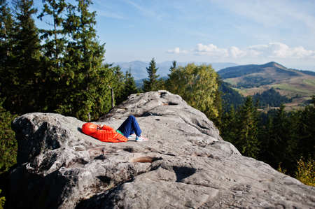 Children hiking on beautiful day in mountains, resting on rock and admire amazing view to mountain peaks. Active family vacation leisure with kids.Outdoor fun and healthy activity.の写真素材