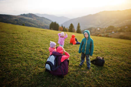 Mother with four kids in the grass gorgeous mountain range in the horizon.の写真素材