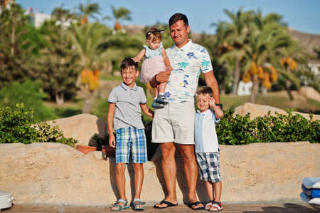 Father with three kids on Turkey resort against palms.の写真素材