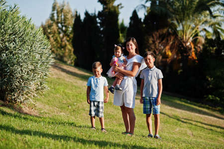 Mother with three kids on Turkey resort against palms.