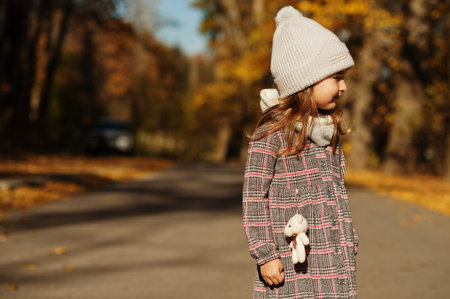 Young cute baby girl in hat pose at autumn background.の写真素材