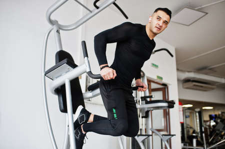 Muscular arab man training in modern gym.