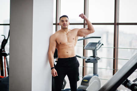 Muscular arab man in modern gym. Fitness arabian men with naked torso show his biceps.の写真素材