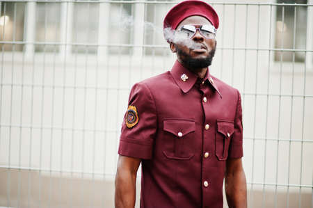 Portrait of African American military man in red uniform, sungalasses and beret. Captain smoke cigar.の写真素材