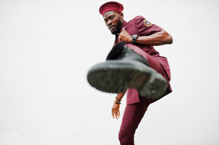 Kick by leg. Portrait of African American military man in red uniform and beret.の写真素材