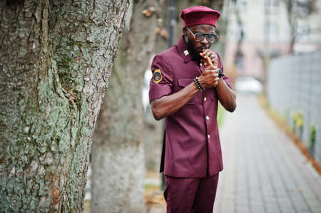 Portrait of African American military man in red uniform, sungalasses and beret. Captain smoke cigar.の写真素材