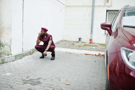 Portrait of African American military man in red uniform and beret near car.の写真素材