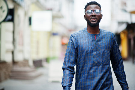 African guy in blue authentic costume, eyeglasses. Fashionable nigerian man.の写真素材