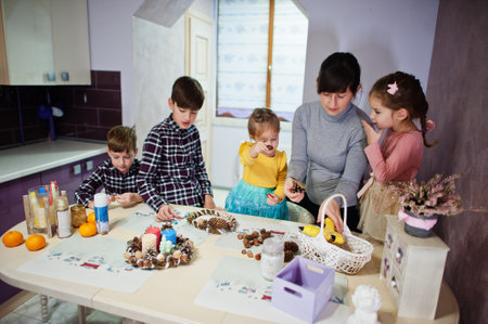 Mother with four kids makes a wreath for Christmas Eve and crafting decorating. New Year...