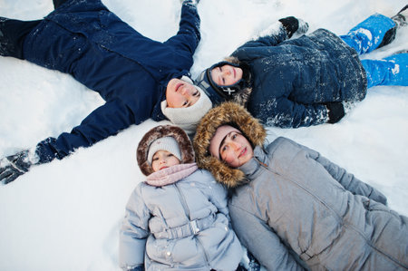 Mother playing with children in winter nature. Outdoors in snow.の写真素材