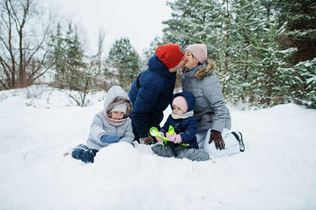 Father and mother with two daughters in winter nature. Outdoors in snow.の写真素材