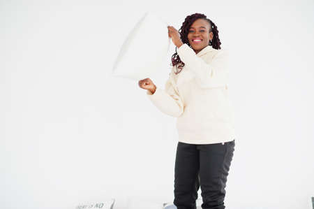 African woman in hoodie hold pillow at home.の写真素材
