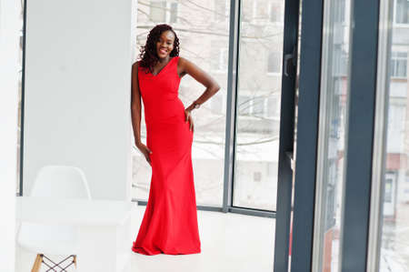 Magnificent young african woman in luxurious red dress in a luxury apartment. beauty, fashion.の写真素材