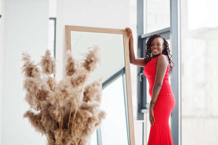 Magnificent young african woman in luxurious red dress in a luxury apartment. beauty, fashion.の写真素材