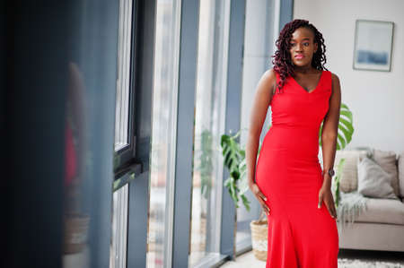Magnificent young african woman in luxurious red dress in a luxury apartment. beauty, fashion.