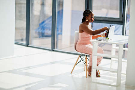 Fashionable photo of young beautiful romantic african american woman with glass of wine, wearing...