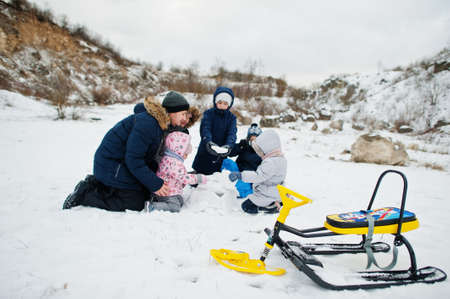 Family plays and sleigh rides in winter outdoor, mother and children having fun.の写真素材