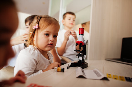 Kids using microscope learning science class at home.の写真素材