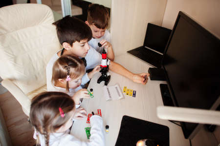 Kids using microscope learning science class at home.の写真素材