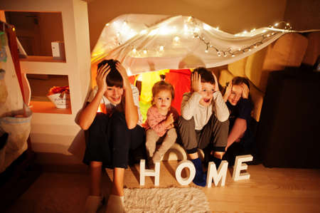 Kids in tent waching tv at night home. Hygge mood.の写真素材